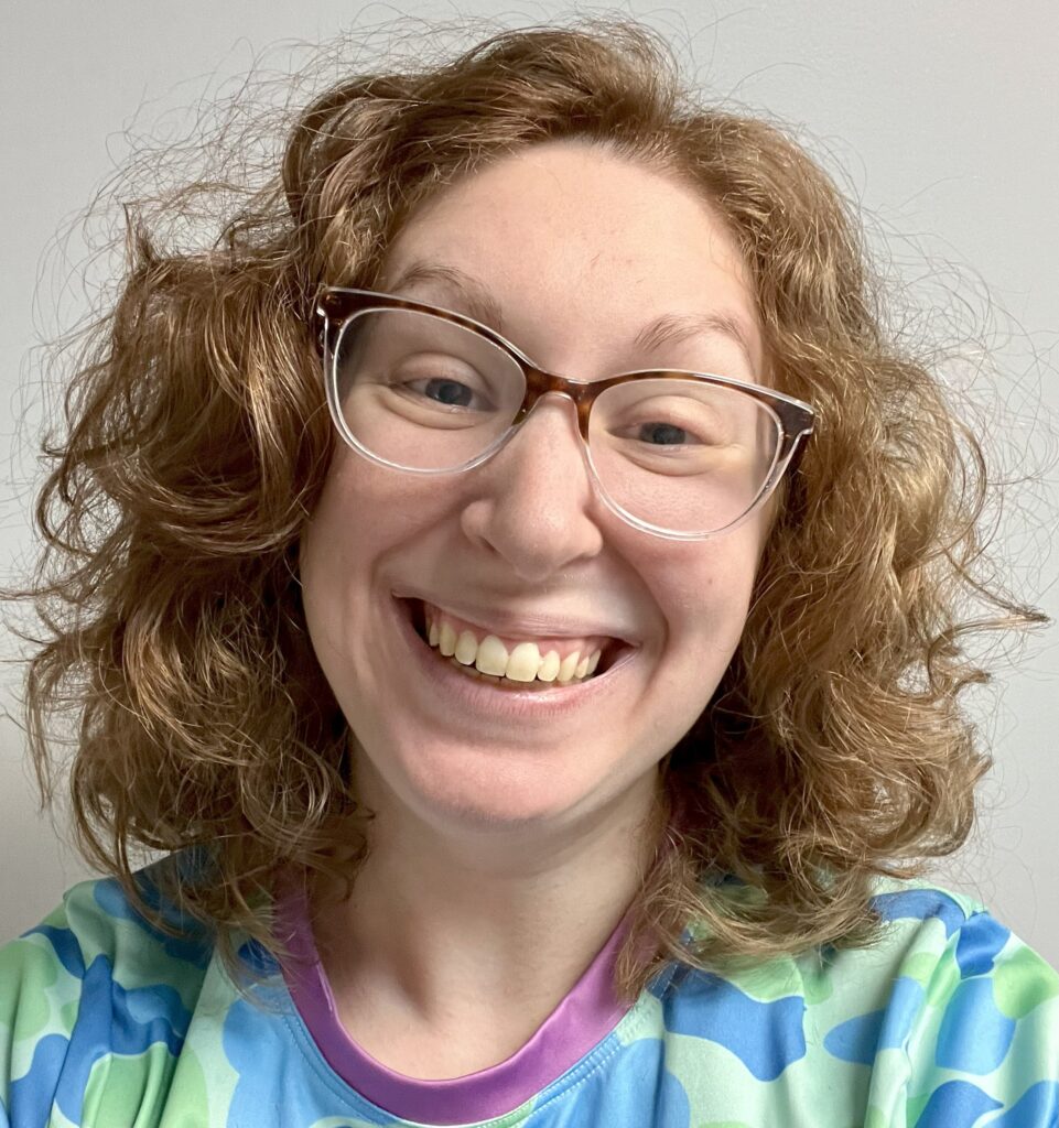 The author, a smiling white woman with hazel eyes and a head of curly red hair.